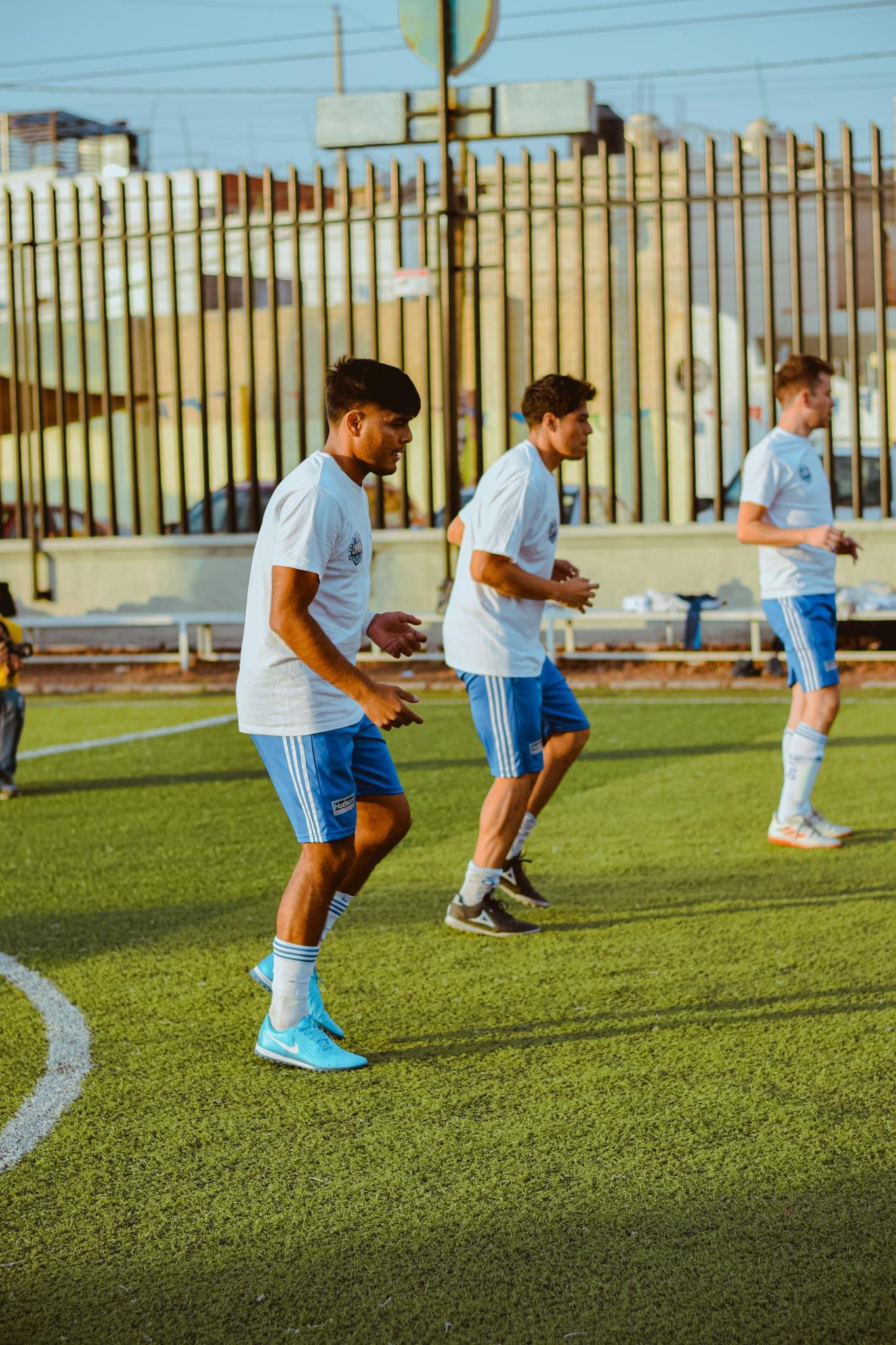 Group of young male soccer players training on a city field.